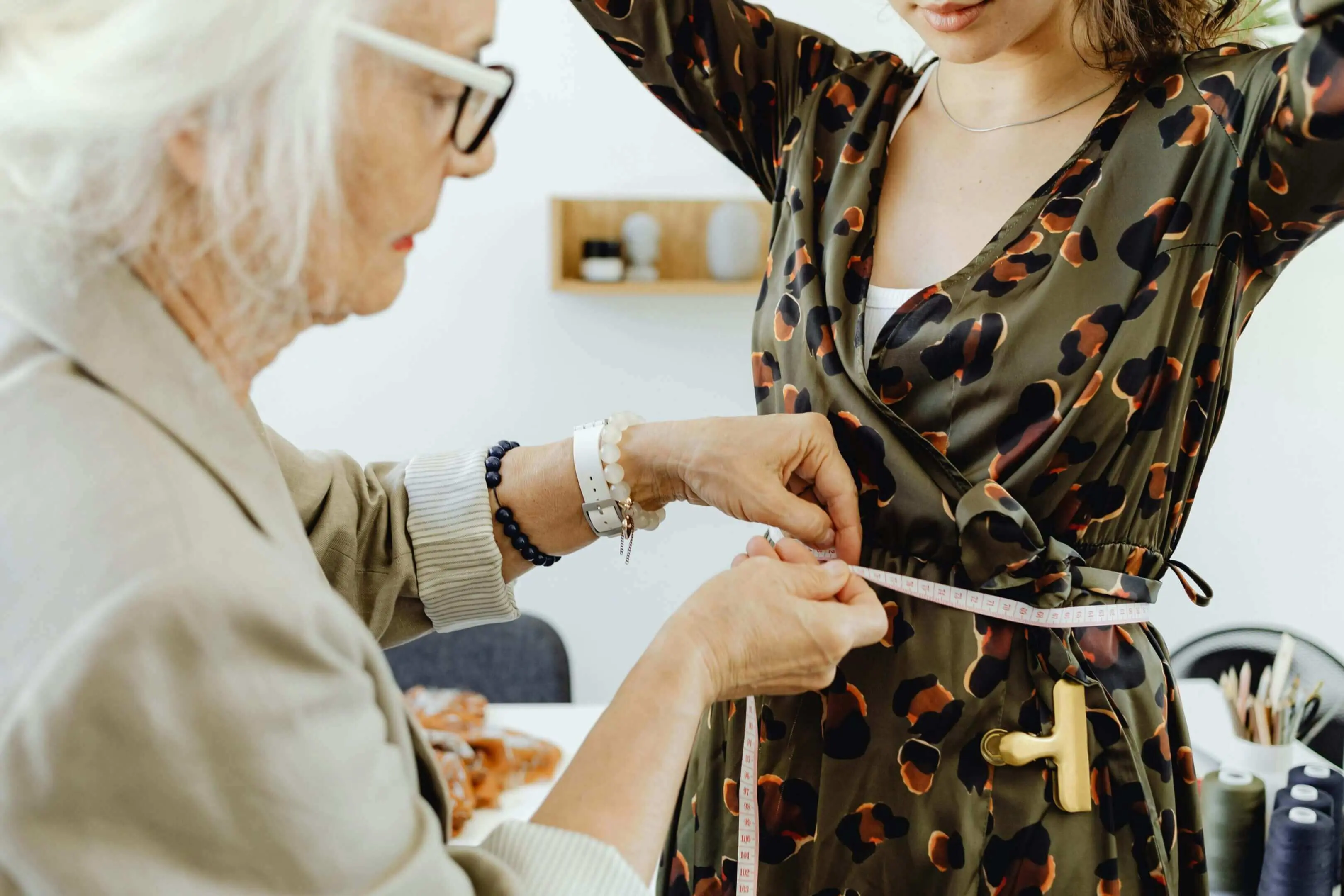 Person measuring dress with a tape measure.