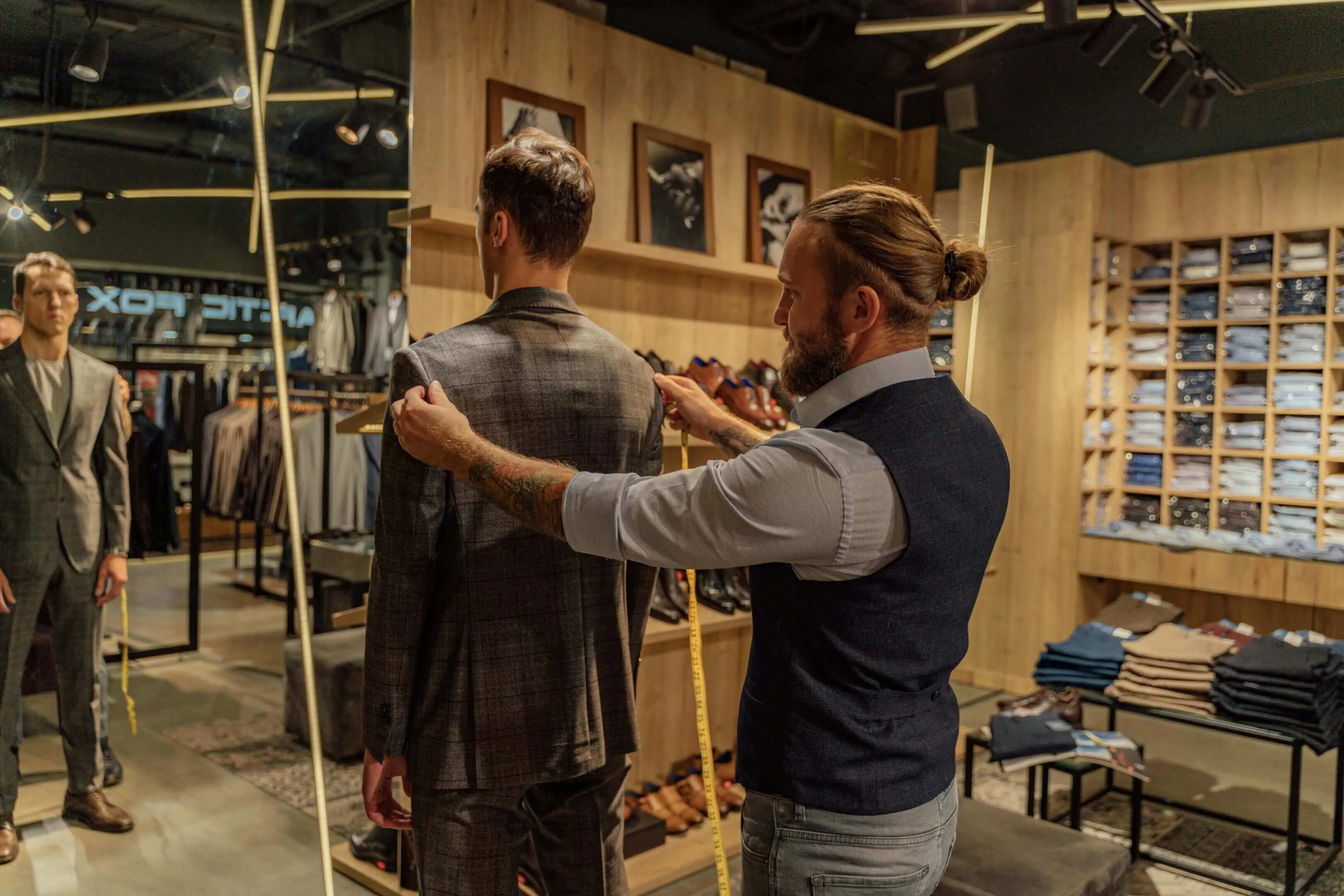 Tailor measuring man for a suit fitting.