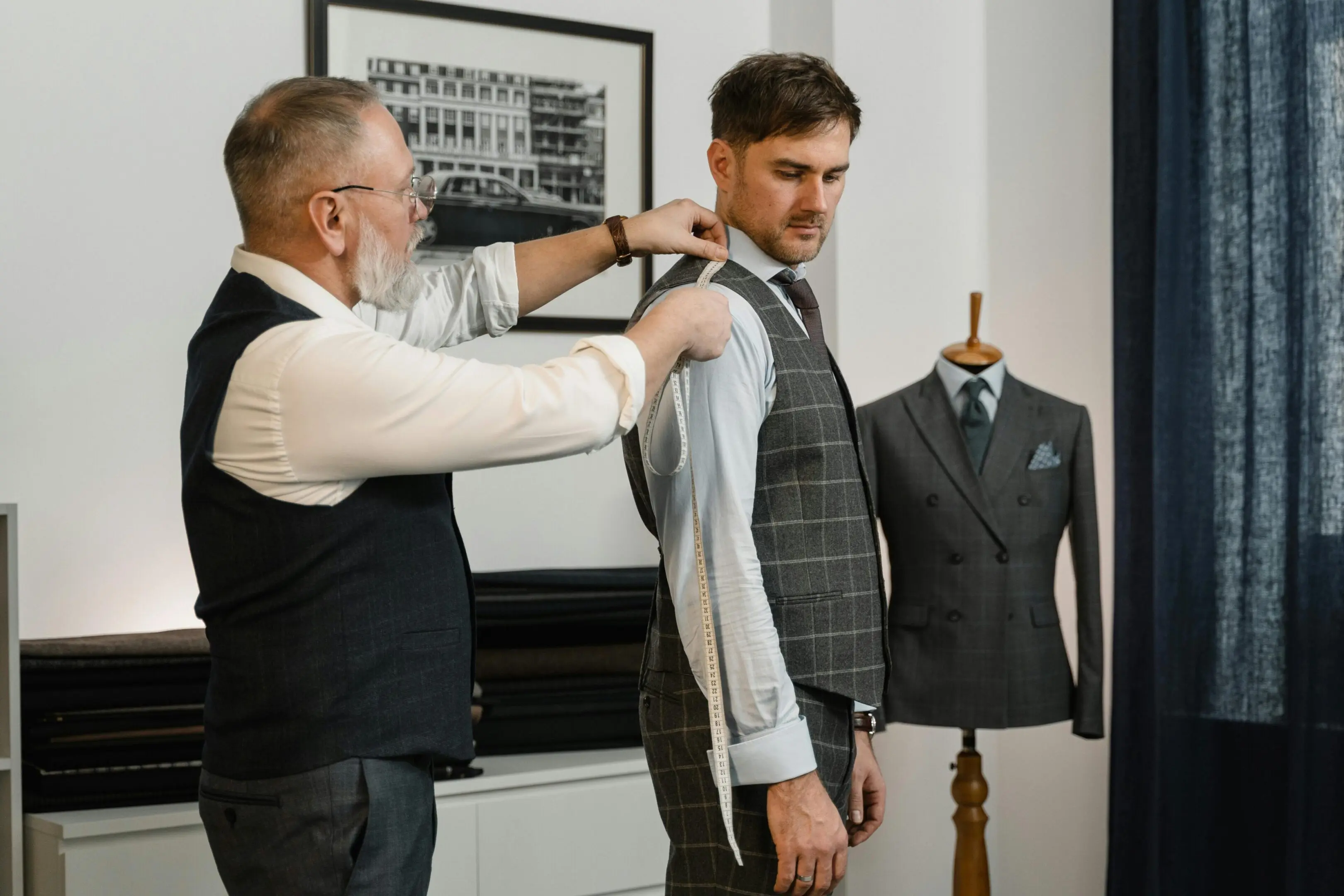 Tailor measuring man for a custom suit.