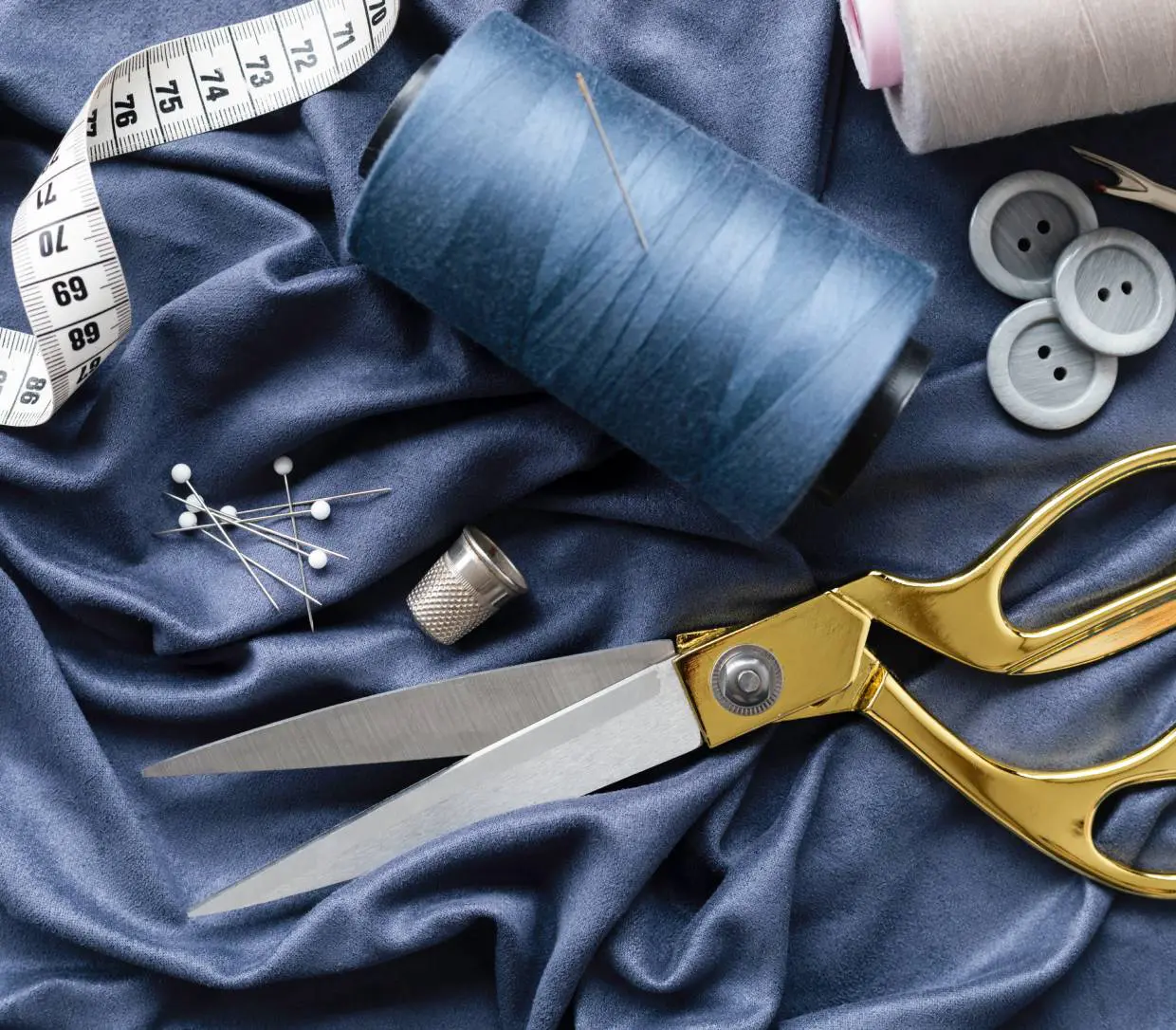 Gold scissors and blue sewing supplies on fabric